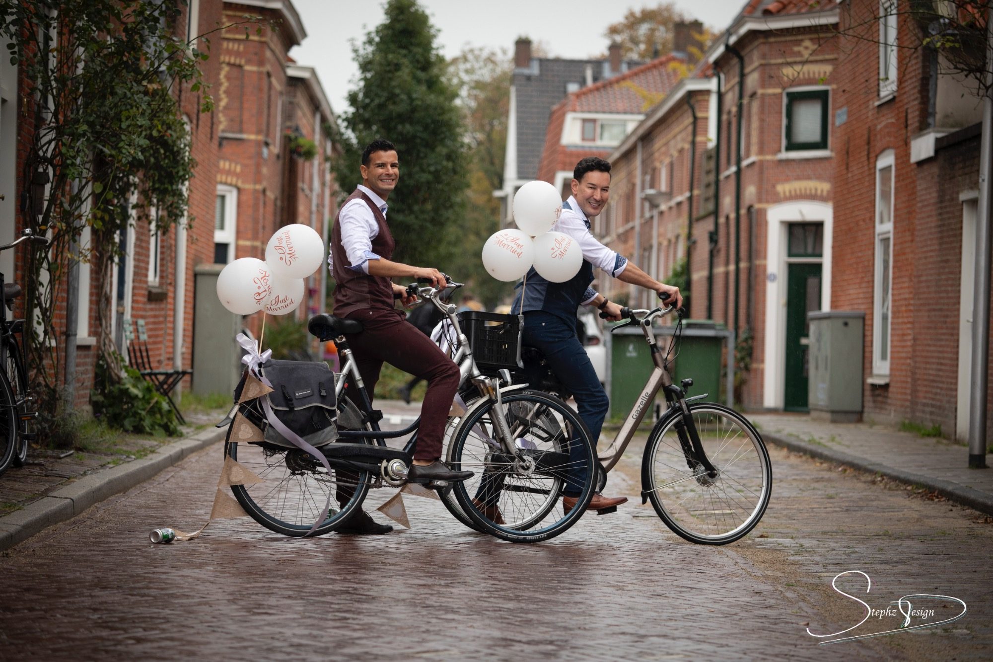 Een mooi bruidspaar op de fiets in een authentieke straat in Leiden. 